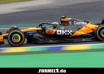 Lando Norris mit einer Hand auf dem WM-Pokal